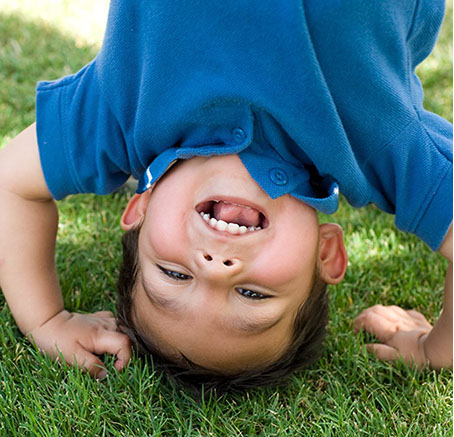 boy in blue shirt doing somersault